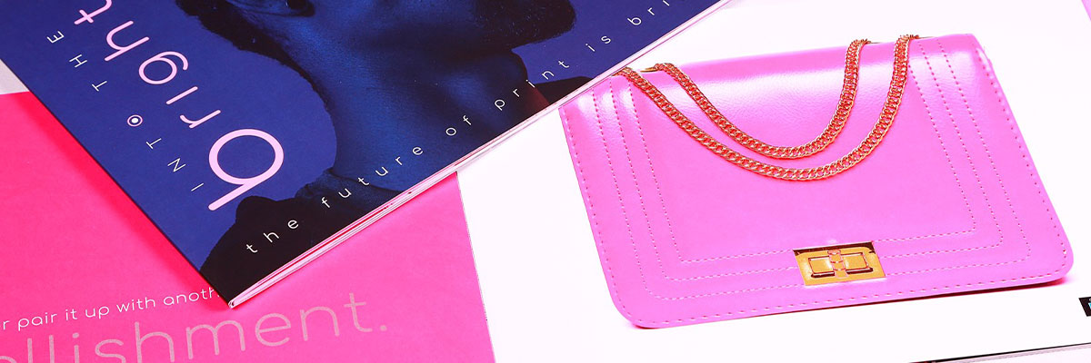 A pink purse and a pink and blue magazine 