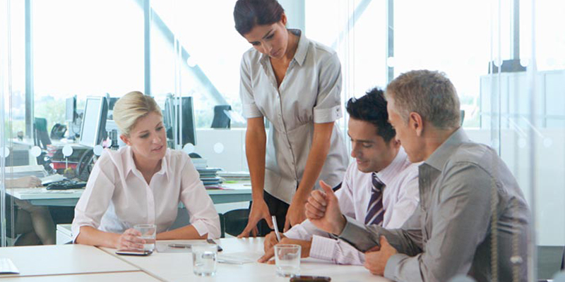 Business people meeting around a table looking at paperwork