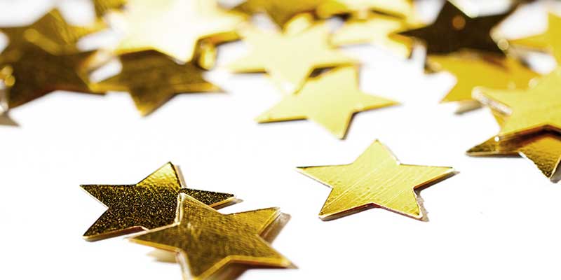 Gold sparkly stars on a white background