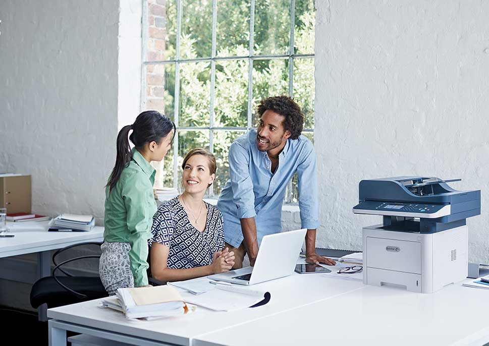 3 colleagues next to a Xerox MFP