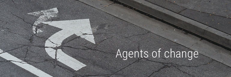 Photo of a street with an arrow on it, overlaid with the words "Agents of Change"