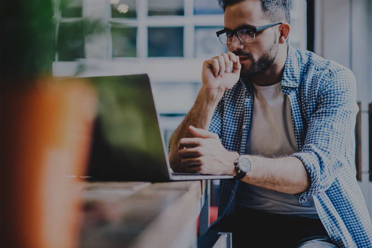 Man sitting at laptop thinking.