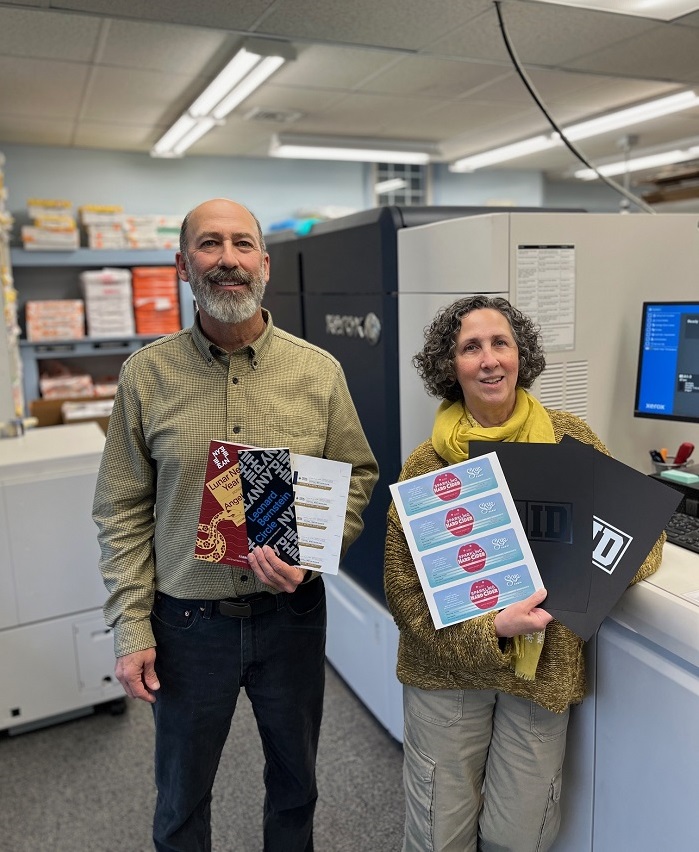 Bill Fishman and Hilary Huaman, co-owners of Rapid Press, holding print samples from their Xerox Iridesse Production Press