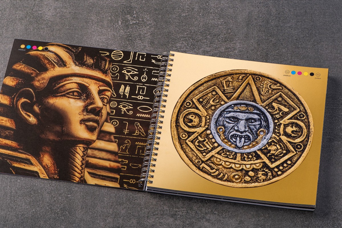 Spiral bound book open to a page with gold images of a pharaoh and an ancient sign.