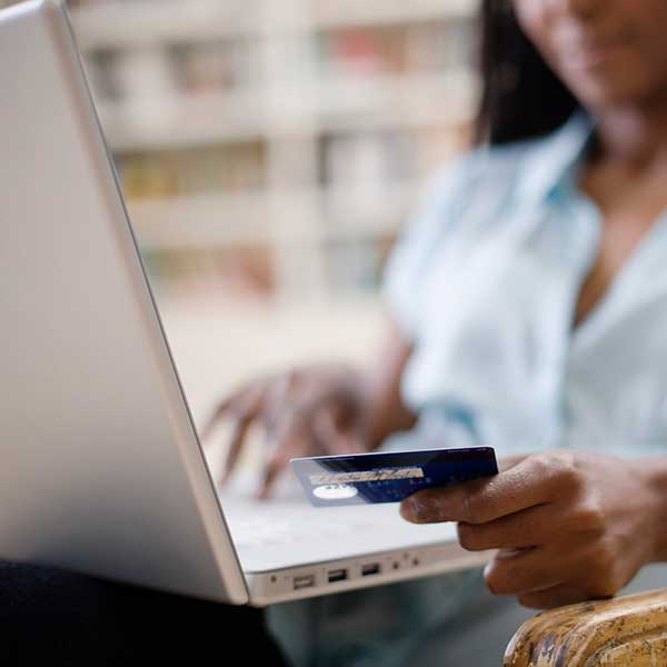 Online shopping - a woman holding a credit card while she uses a laptop