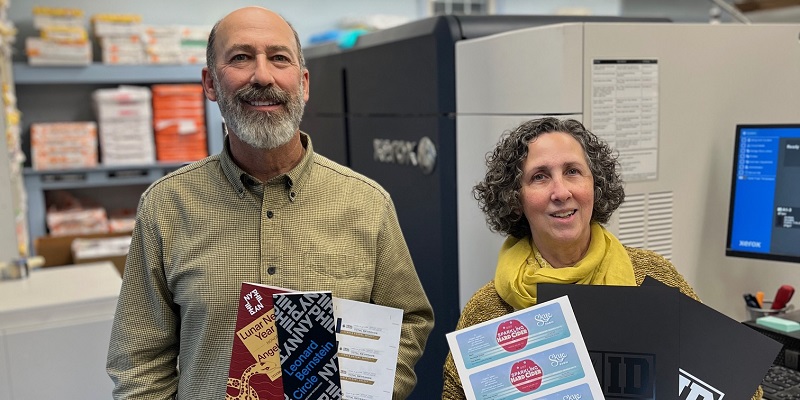 Bill Fishman and Hilary Huaman, co-owners of Rapid Press, holding print samples from their Xerox Iridesse Production Press