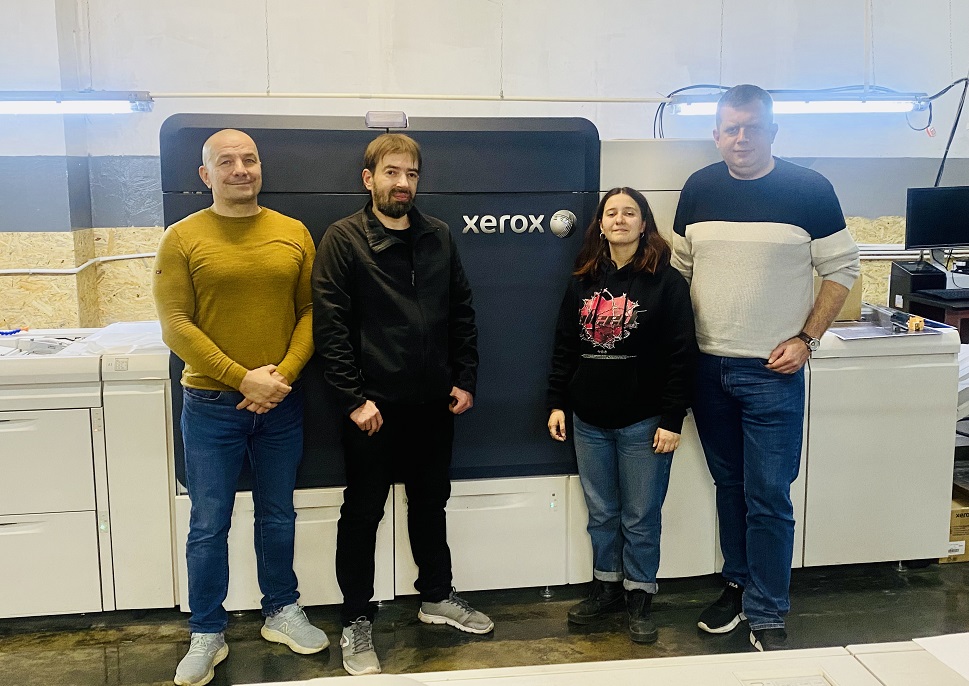 Staff of Wolf Printing House standing in front of their Xerox Iridesse Production Press