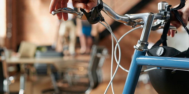 Closeup image of bicycle handlebars, with a blurred office in the background