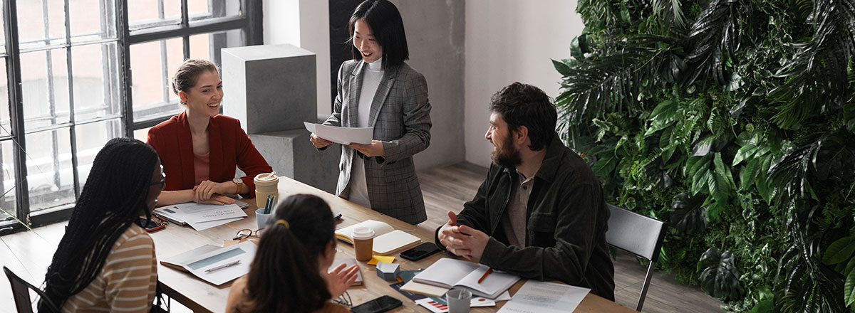 Business people meeting in a room with large windows and a wall of plants