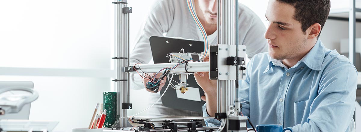 People working on a 3D printer