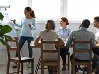 woman at whiteboard presenting to group