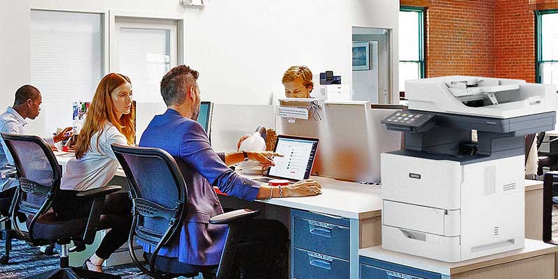 People working in office, with a Xerox VersaLink B625 Multifunction Printer on the desk beside them