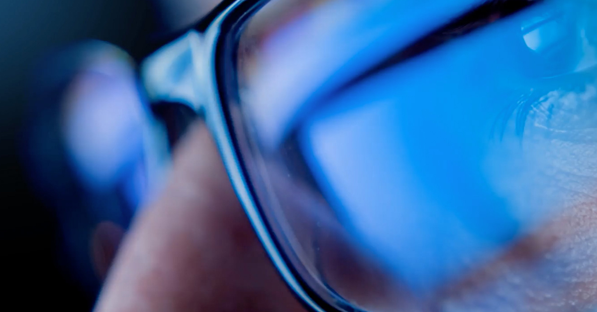 Closeup on glasses that are reflecting data from a computer screen