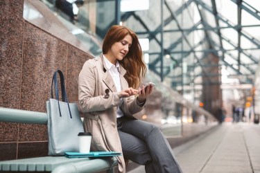 Woman sitting on bench with mobile phone