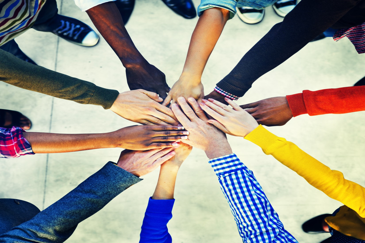 People putting their hands in the center doing a handshake. 