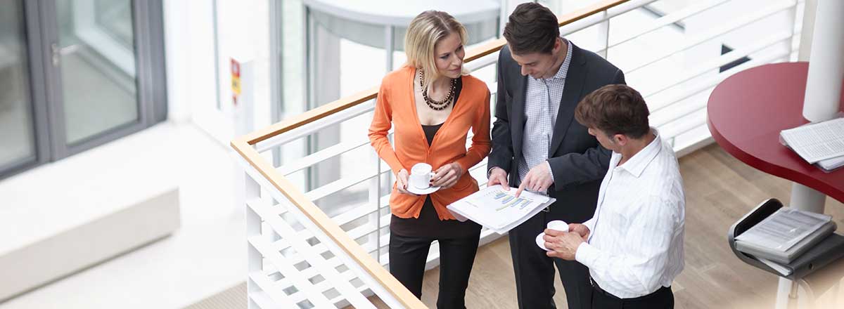 Overhead view of 3 professionals looking at a report