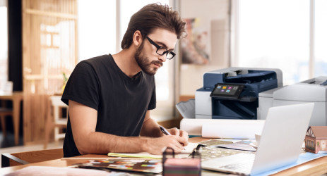 Man using a Xerox MFP, overlaid with "Before: 40 hours per month" and "After: 10 hours per month"