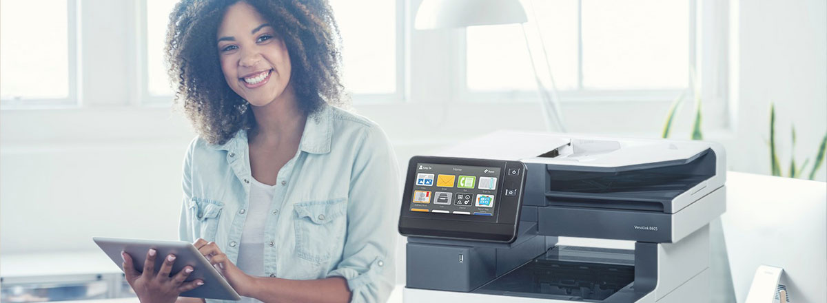 girl on tablet sitting next to versalink printer