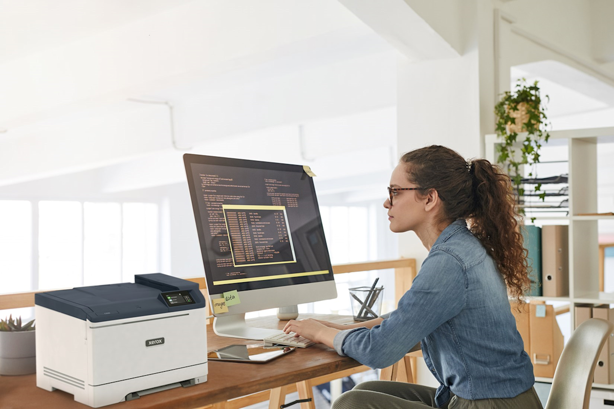 Woman sitting at desk looking at computer. 