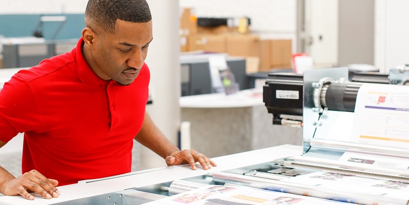 Man looking at fresh prints