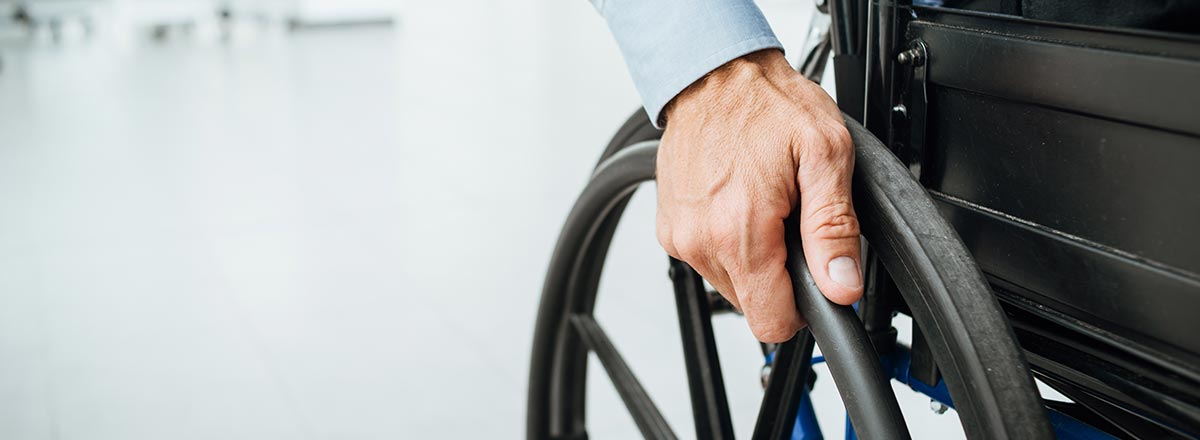 Man turning the wheels of a wheelchair
