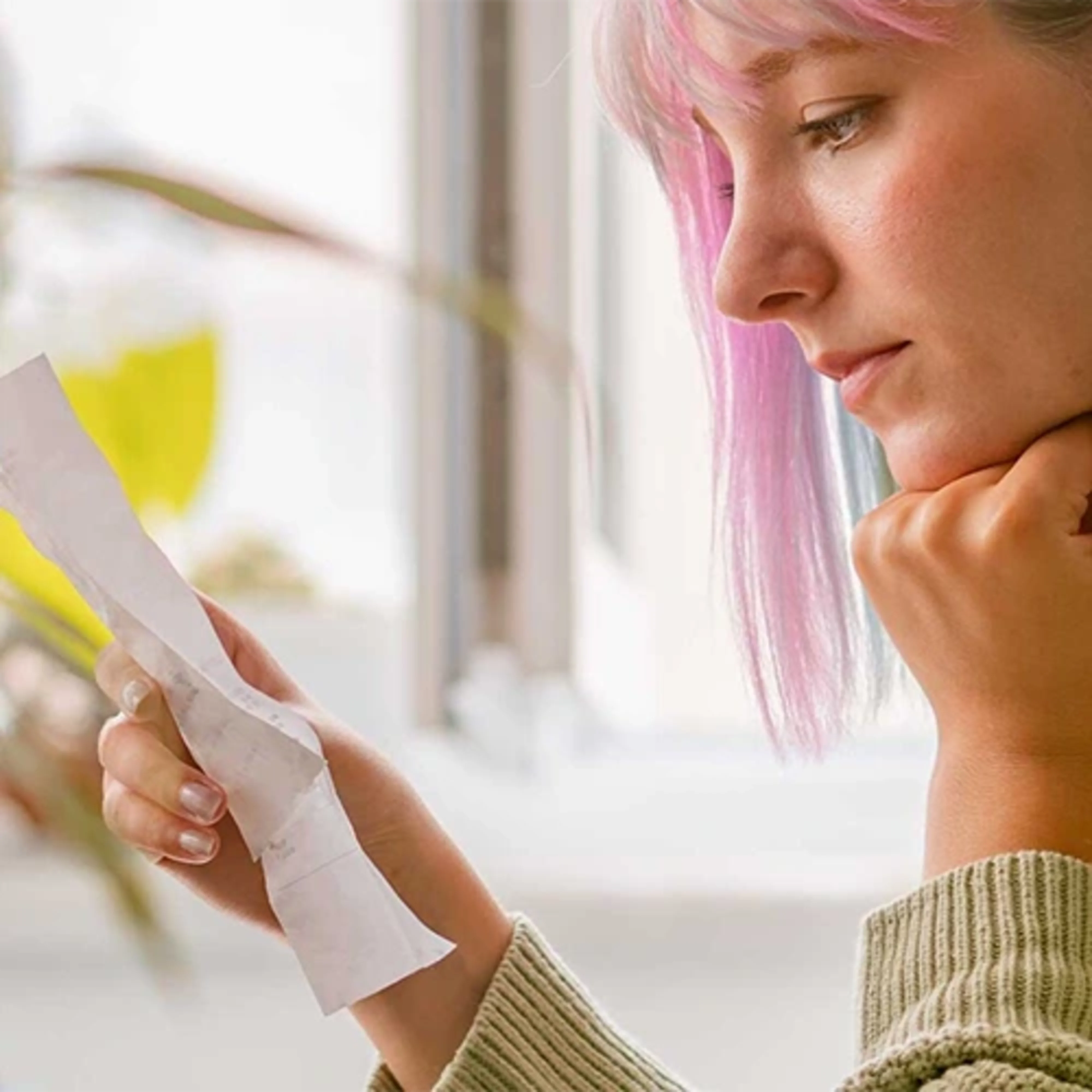 Person reviewing a receipt thinking about overdraft fees and how to avoid them.