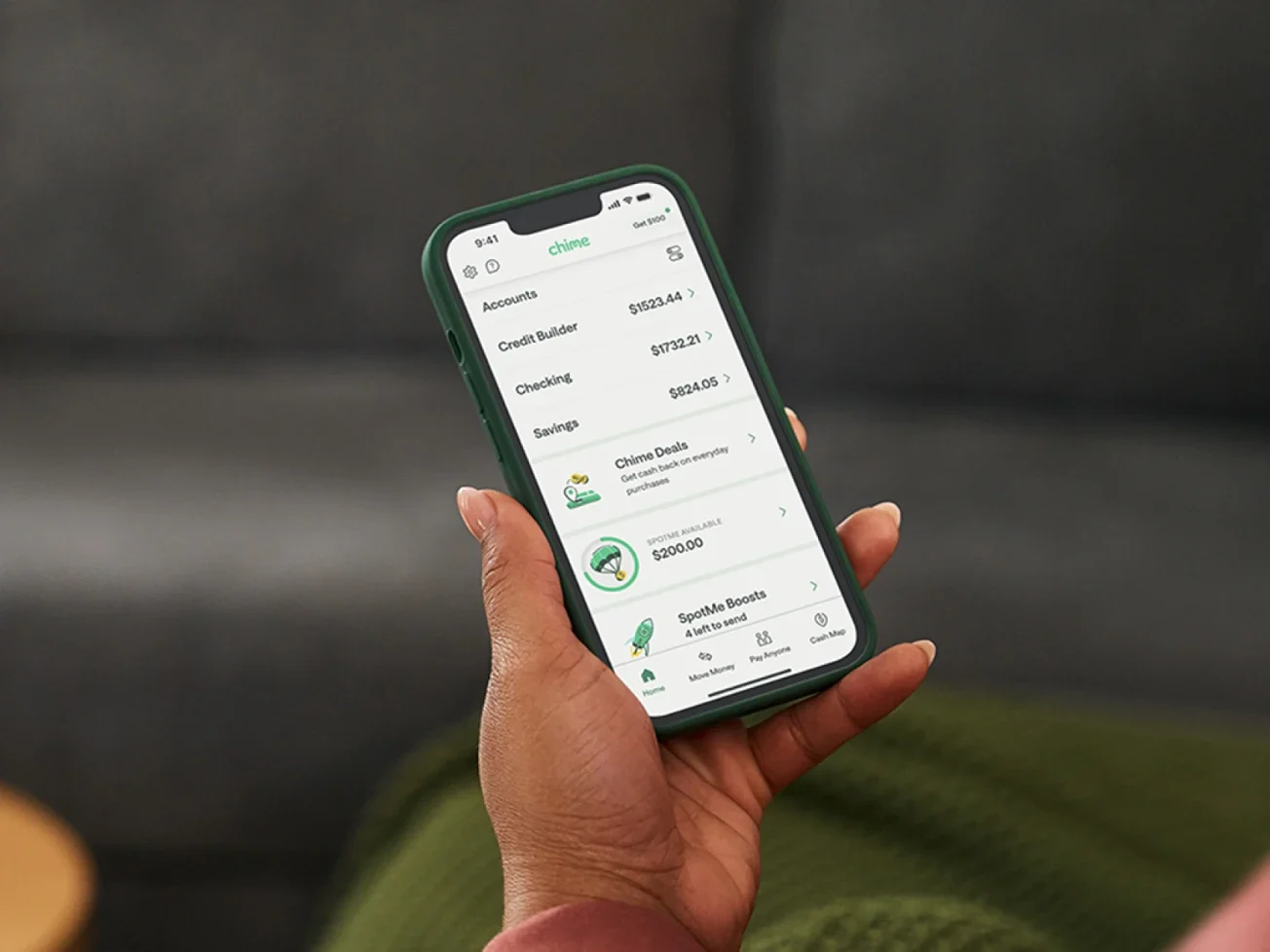 Person holding a smartphone showing Chime app with visible account balances and SpotMe features.