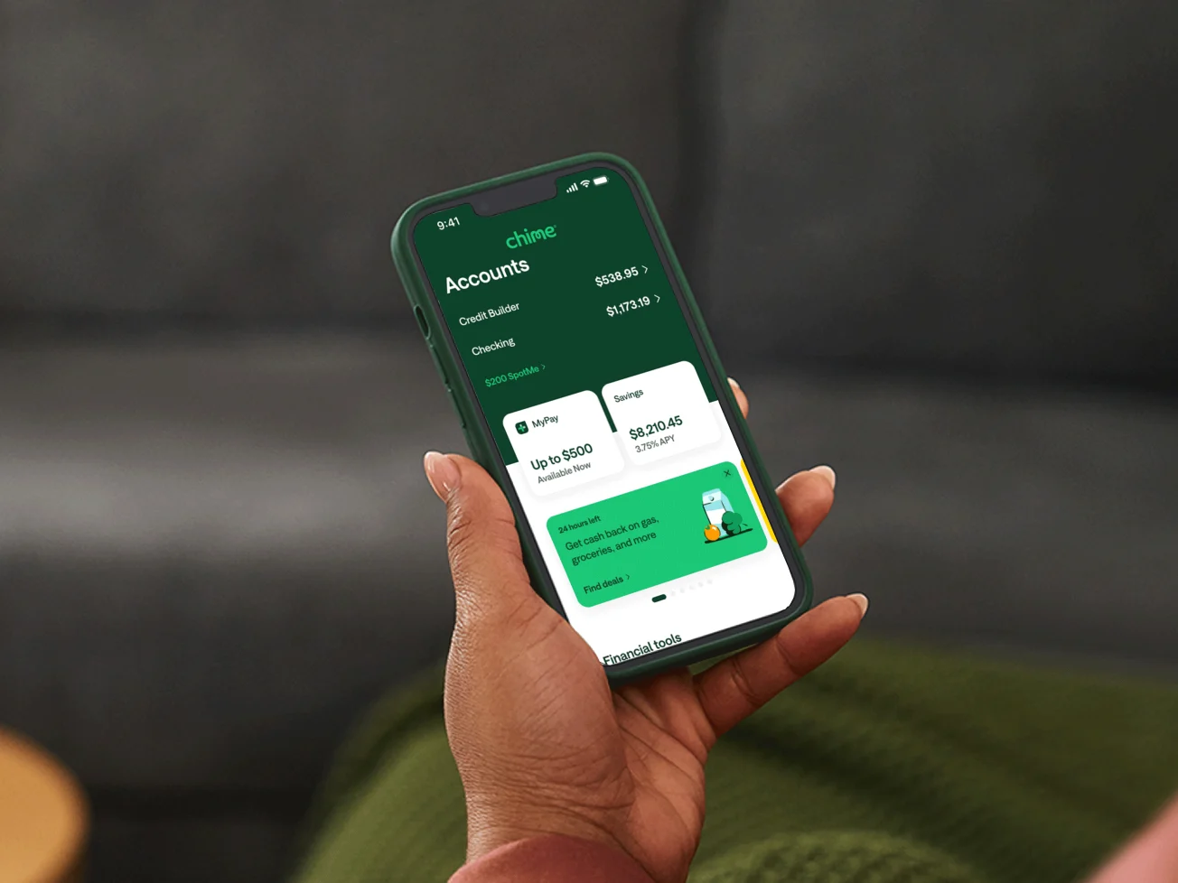 Person holding a smartphone showing Chime app with visible account balances with SpotMe and MyPay features.