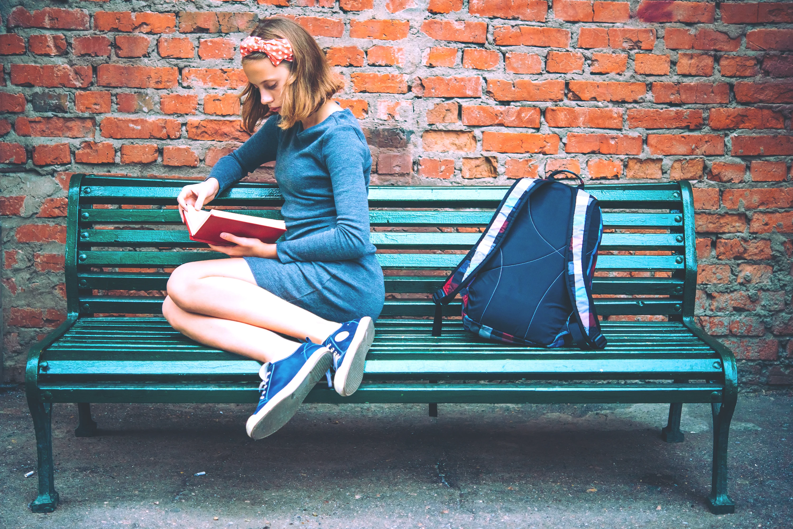 Girl sitting on a bench and reading a book