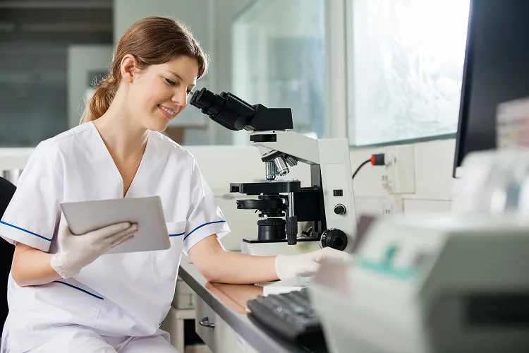 Woman in laboratory next to the microscope
