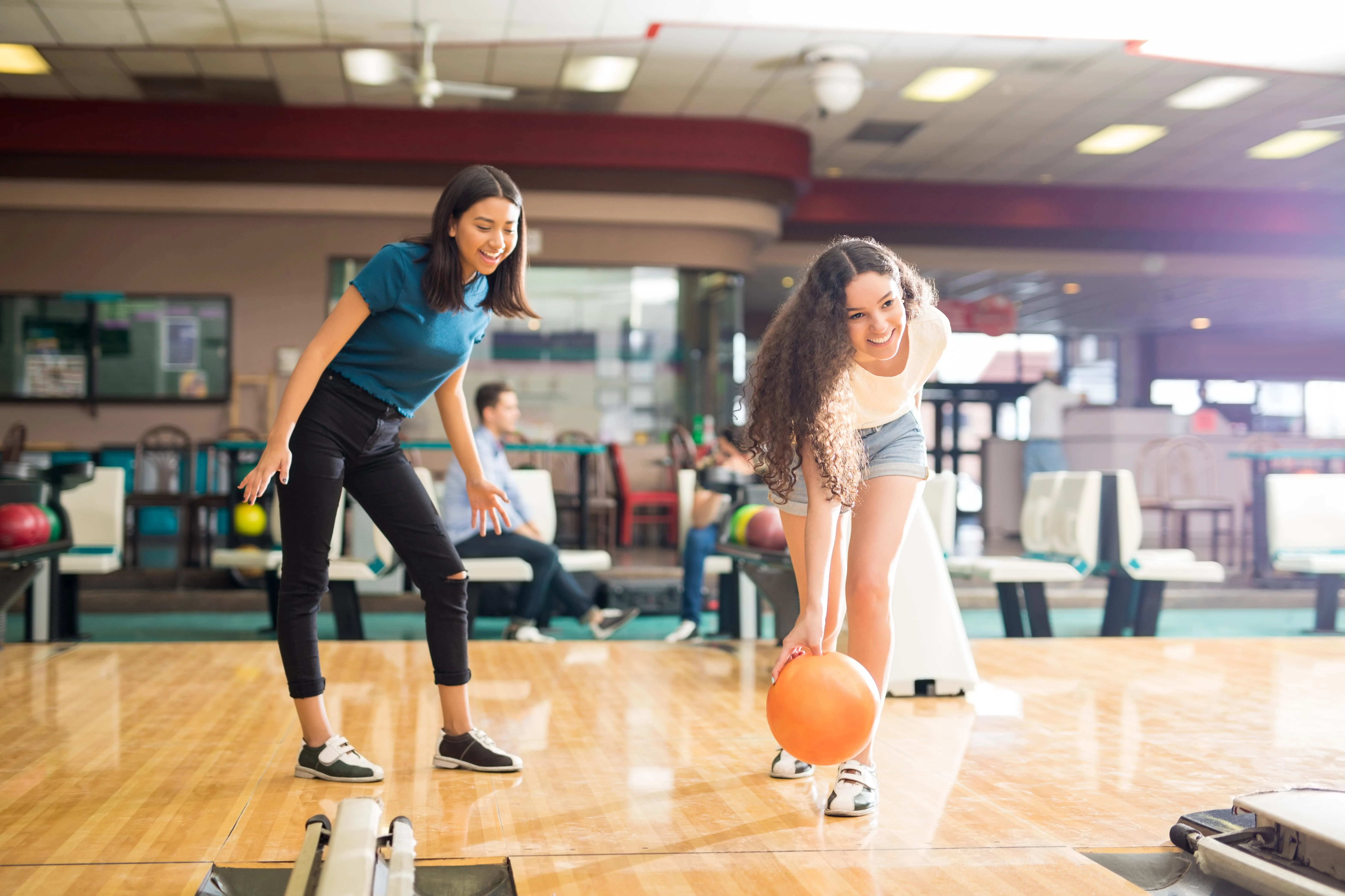 Two girls playing bowling