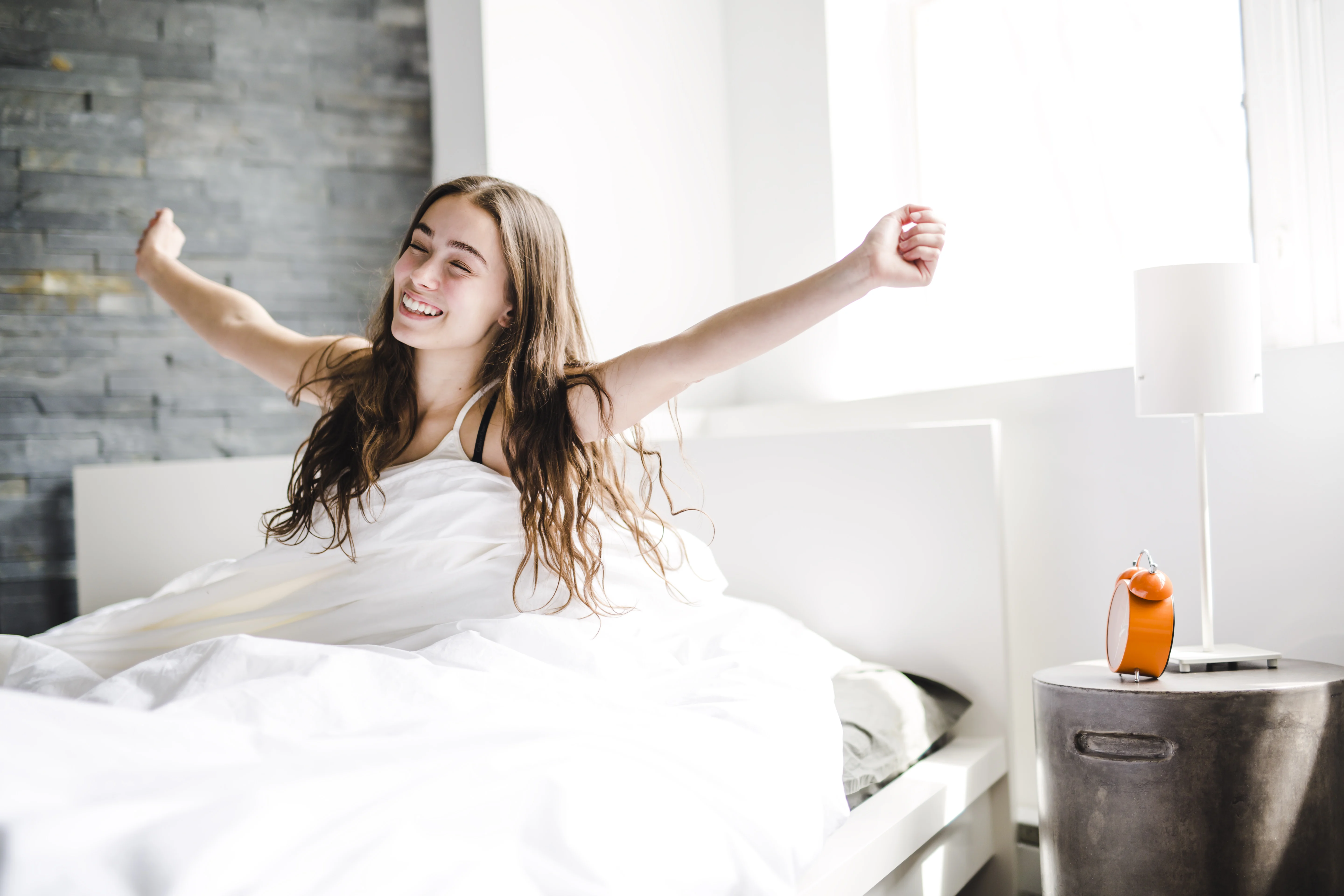 Girl waking up and stretching in bed