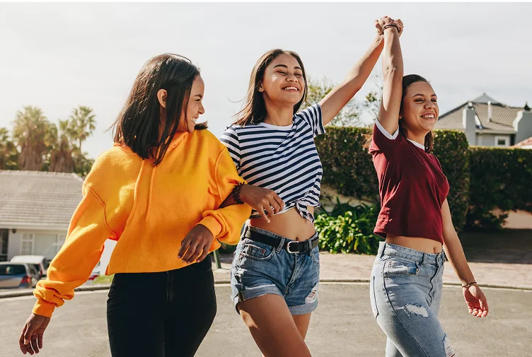Girls walking and smiling while holding hands
