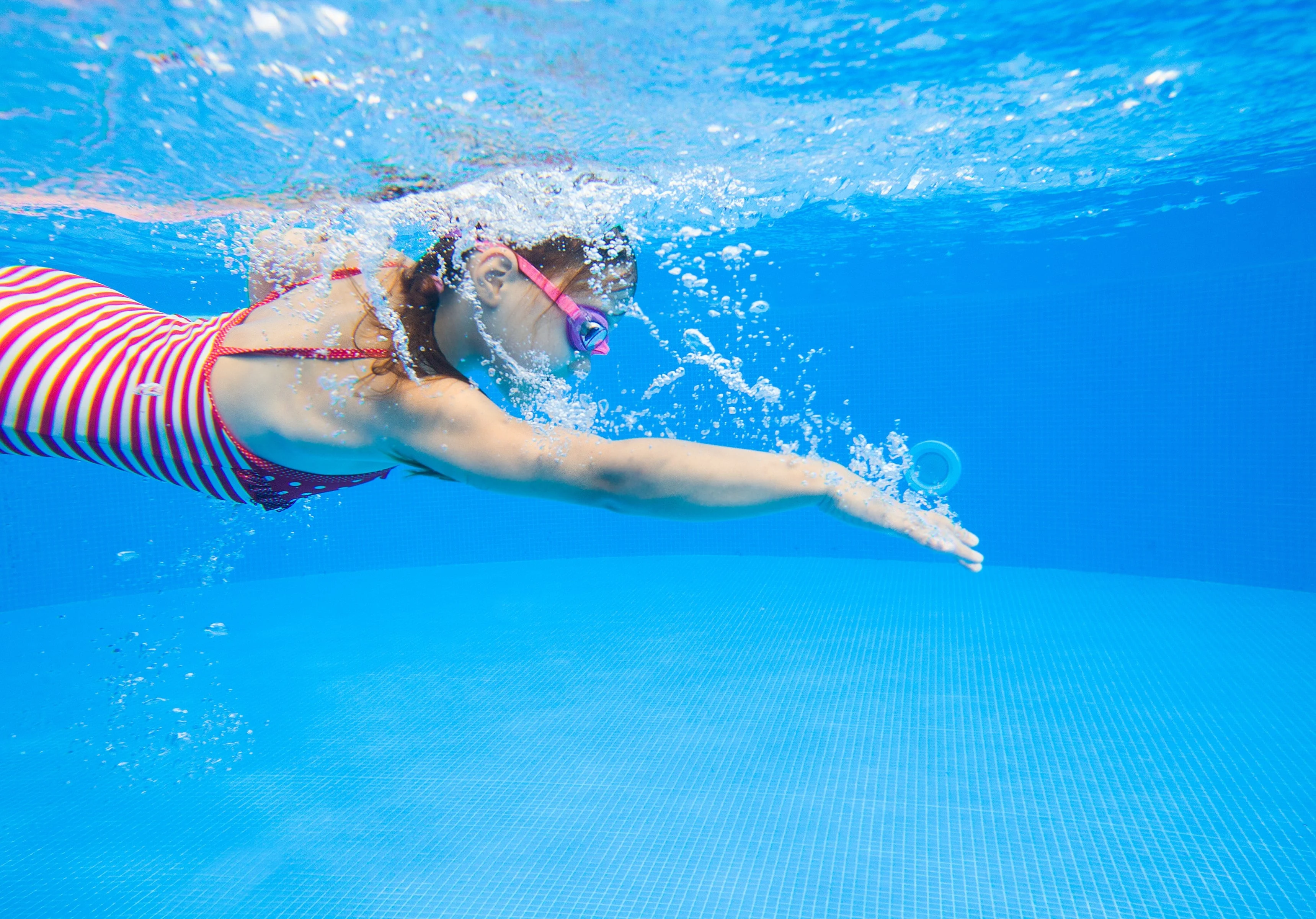 Underwater photo of a girl swimming in the pool