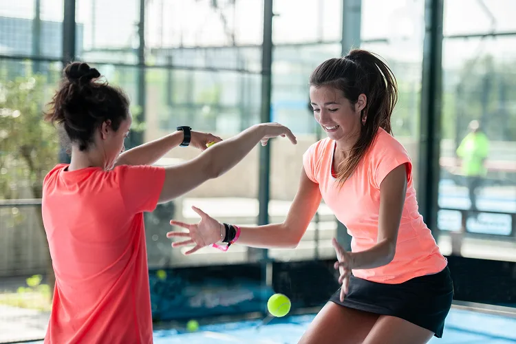 Two women playing with a tennis ball