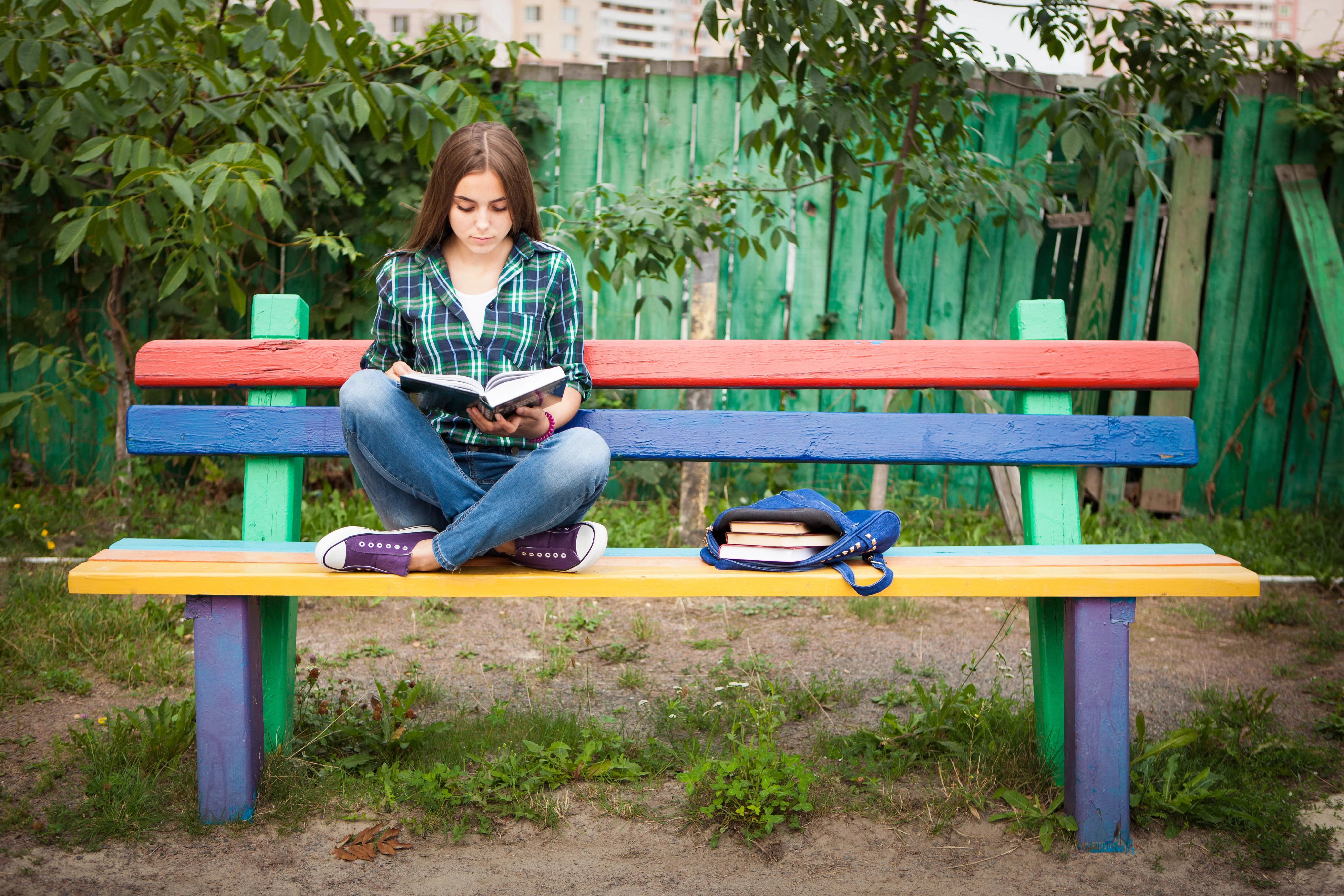 Girl sitting and reading on a coloured bench