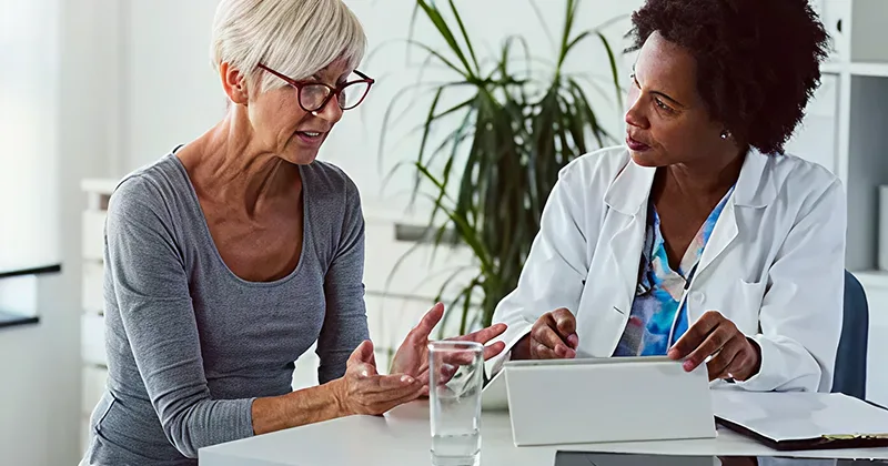 Middle aged woman talking to a doctor in ordination