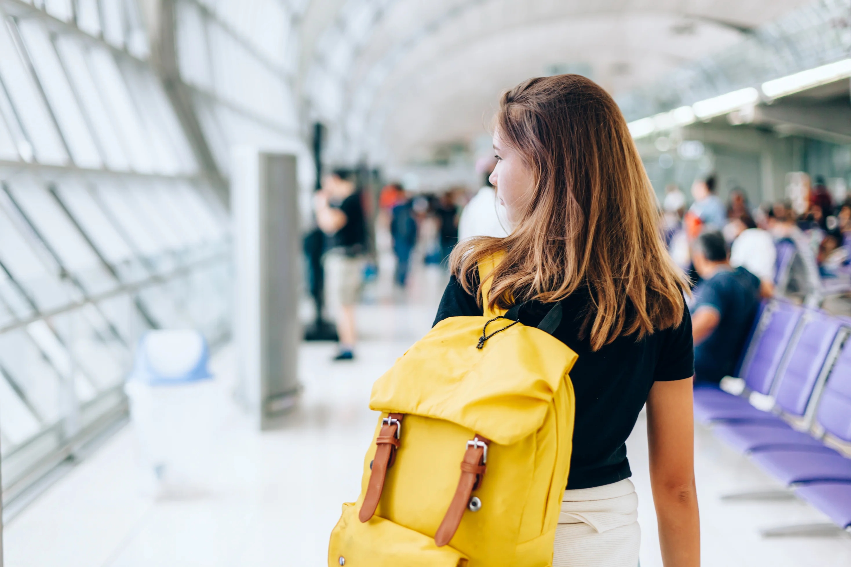 Rear photo of a girl wearing yellow backpack