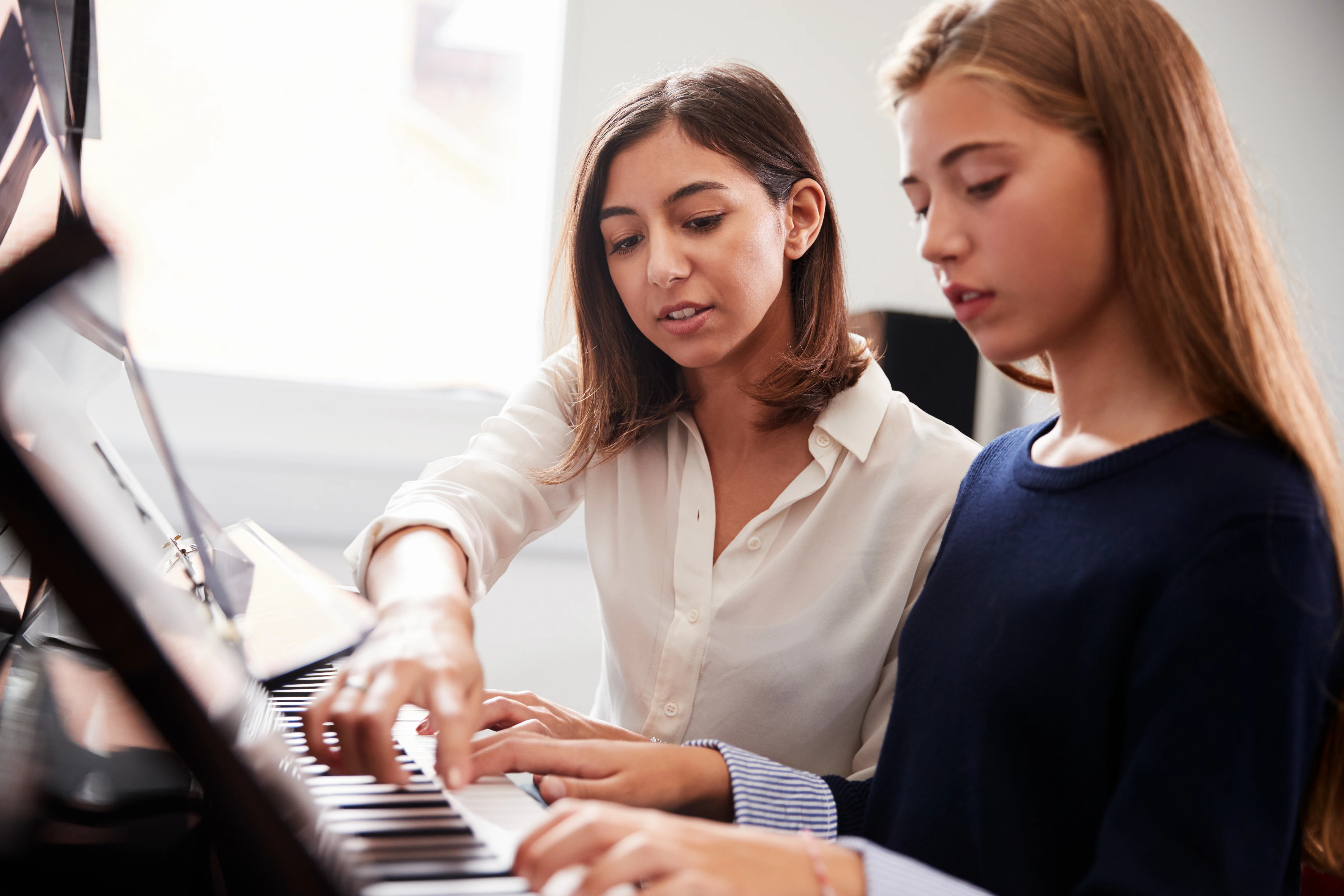 A young girl with the piano teacher