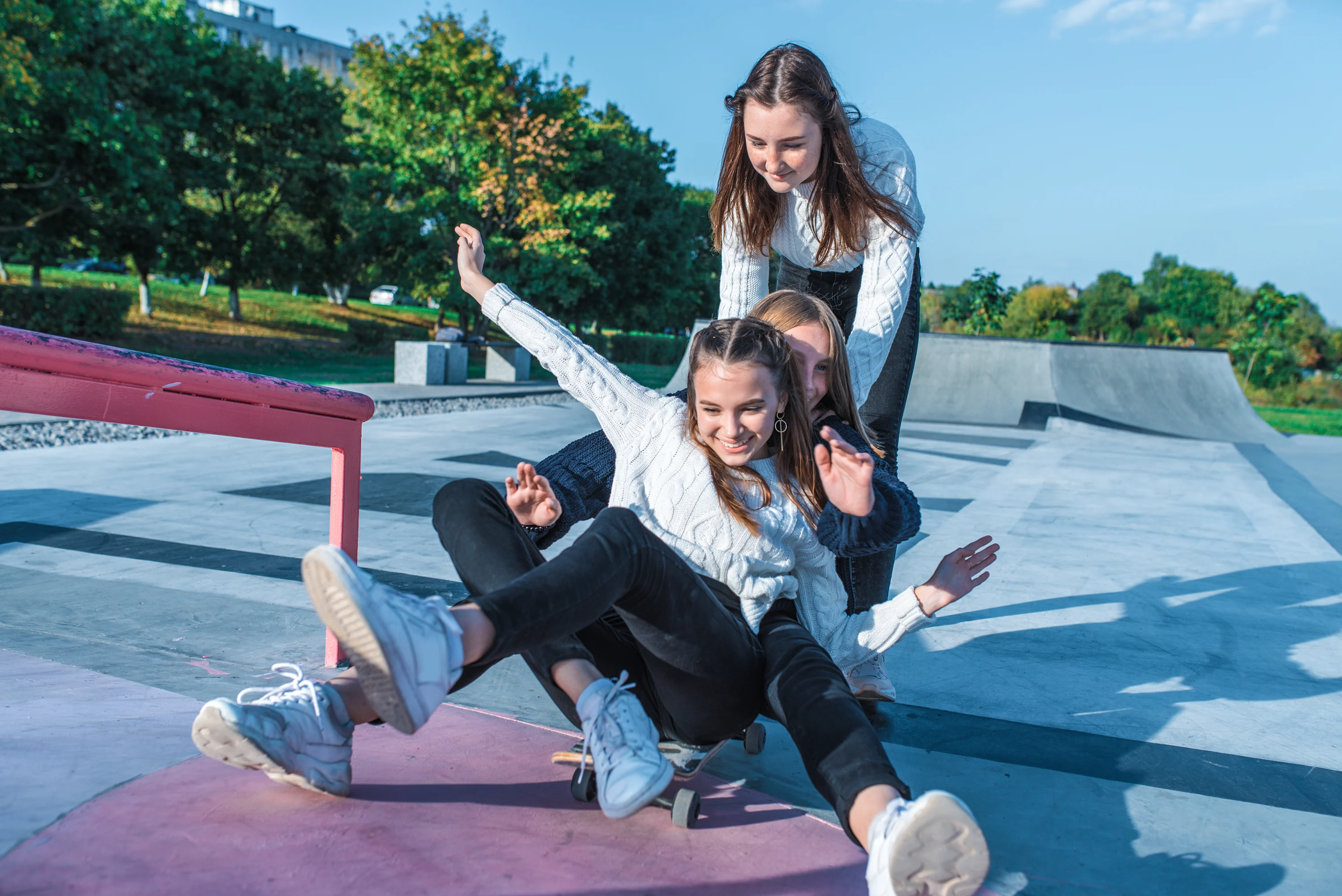 Girls playing and riding a skateboard