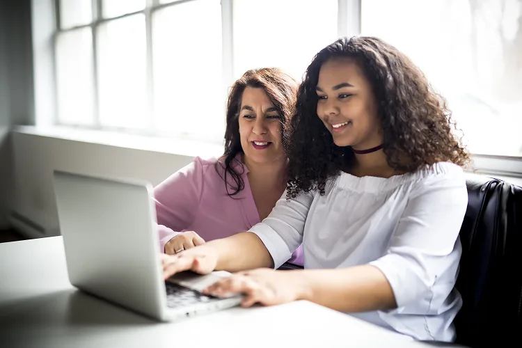 Mother and daughter looking at a laptop screen
