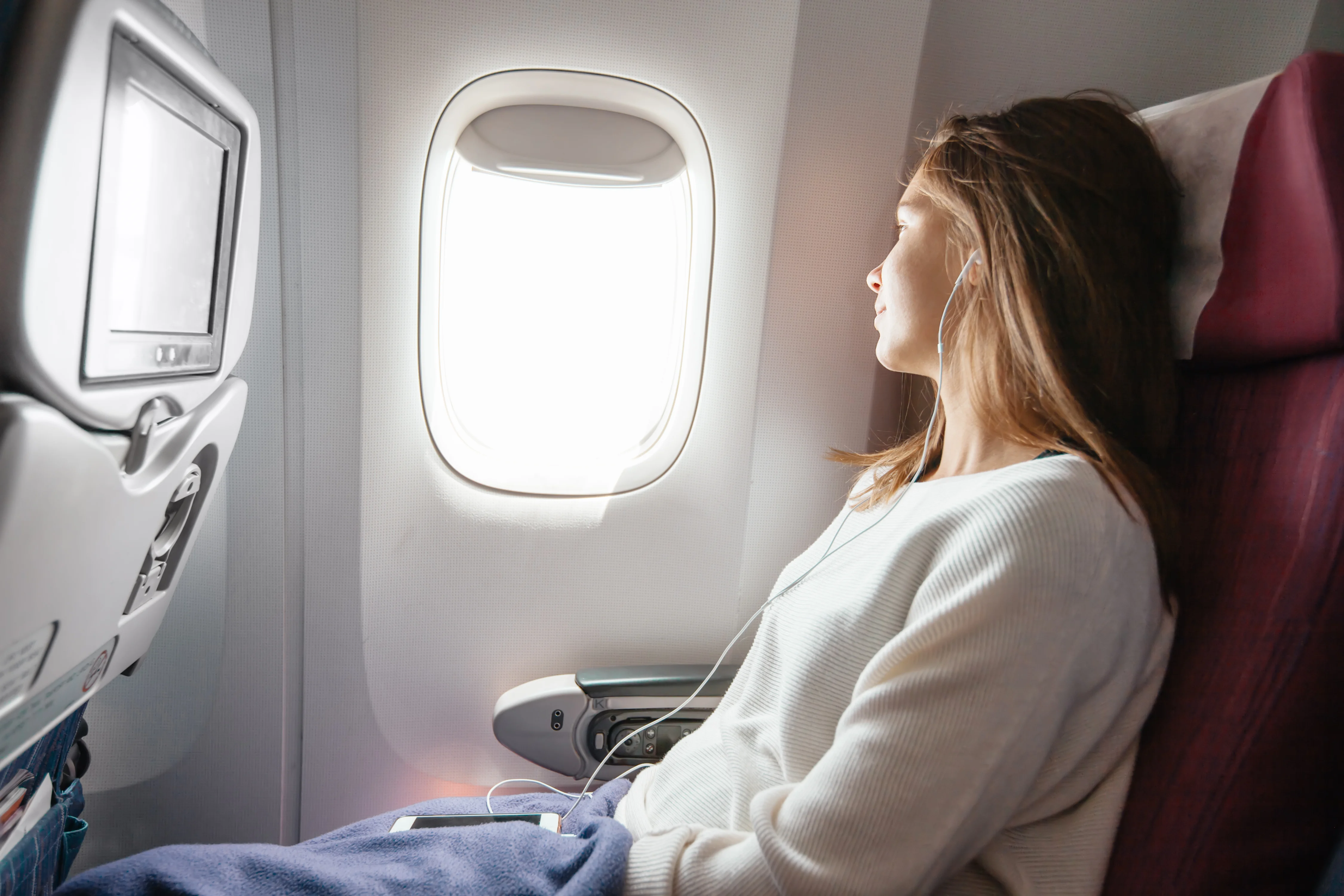 Girl looking through airplane window