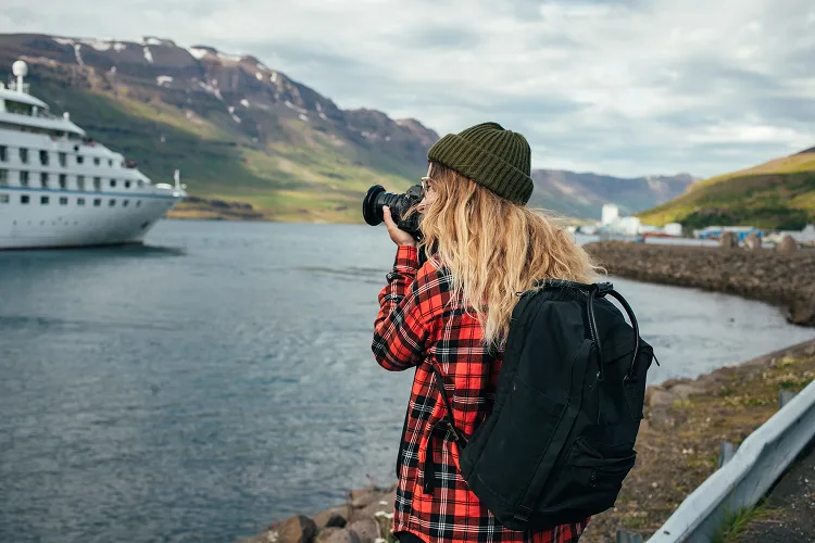 Girl taking a photo of a boat