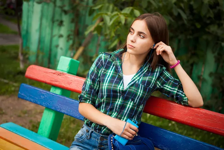 Girl sitting on a bench and looking at the distance