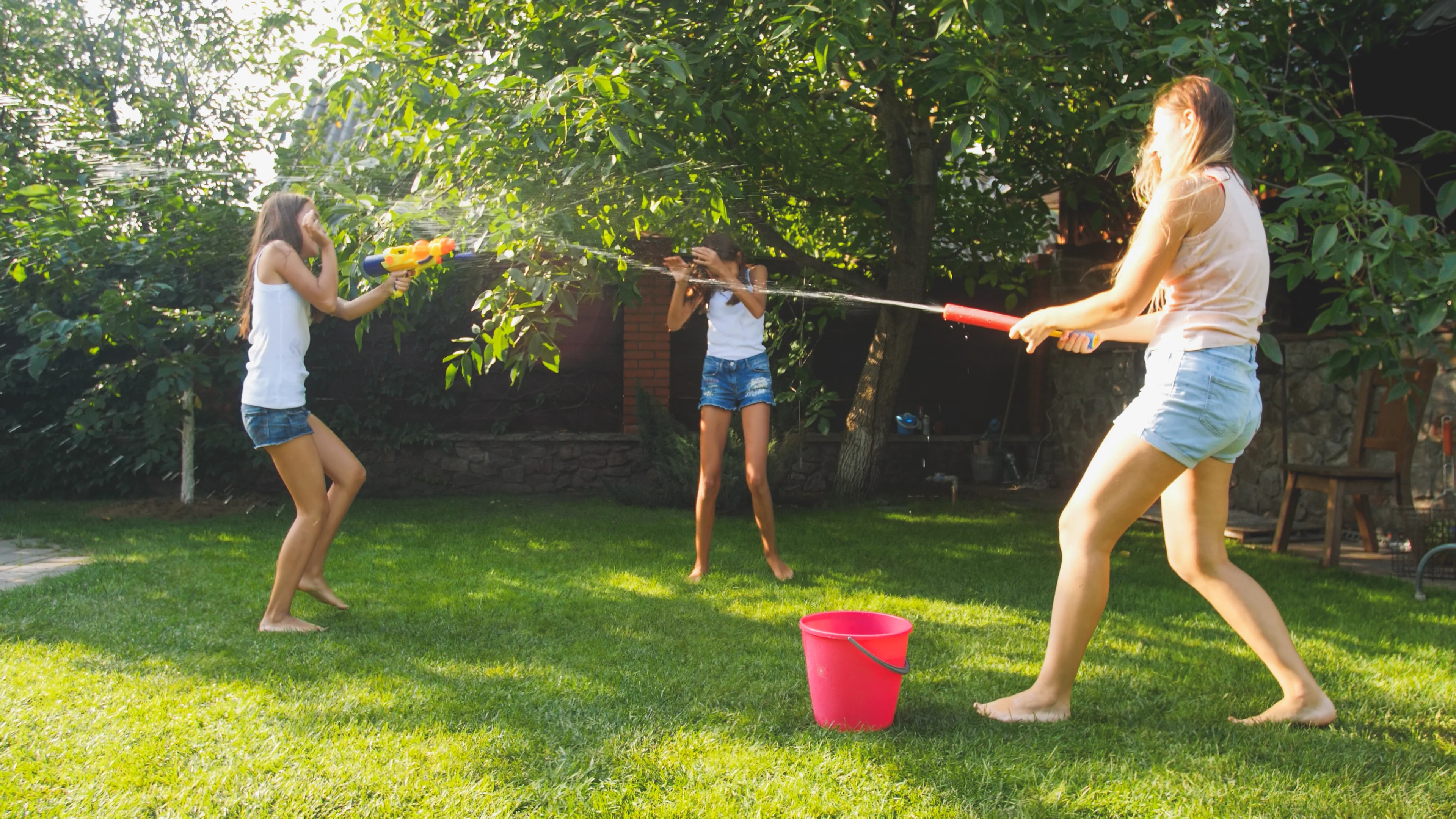 Girls playing with garden sprinkler
