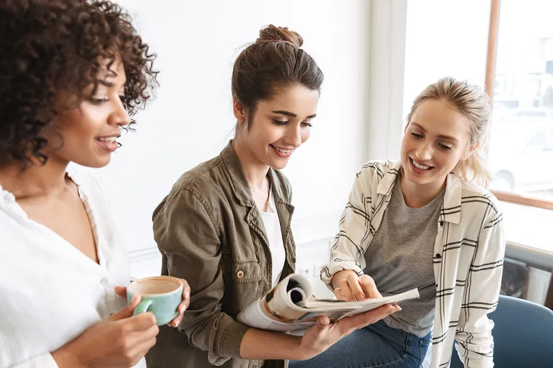 Three women reading about ovarian cysts
