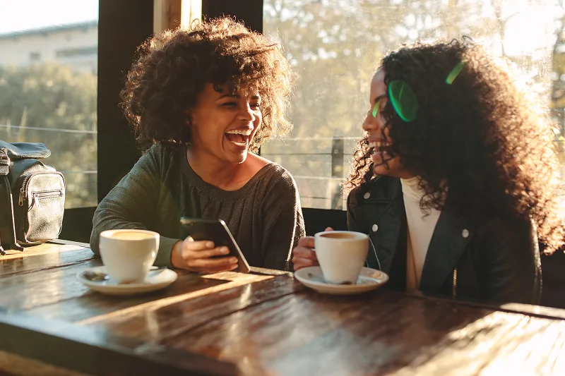 Two women smiling in a cafe bar