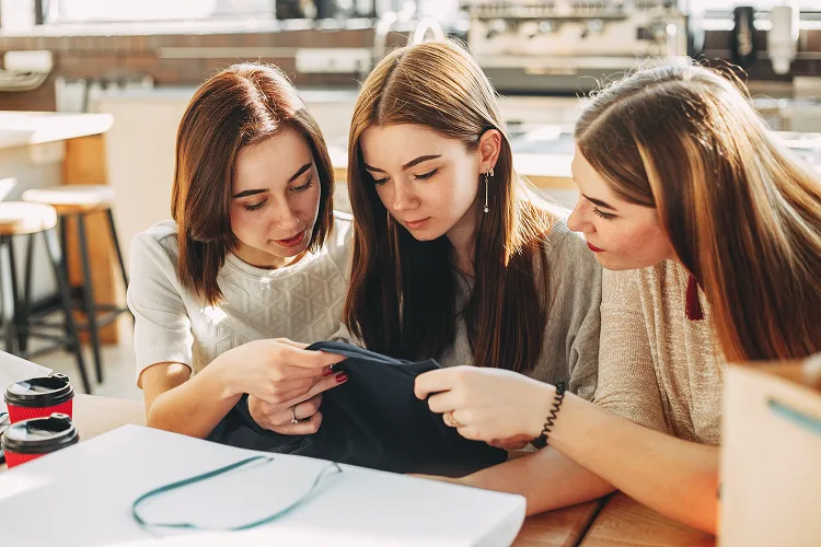 Three girls holding a piece of fabric