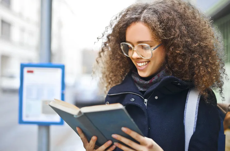A girl reading a book and smiling