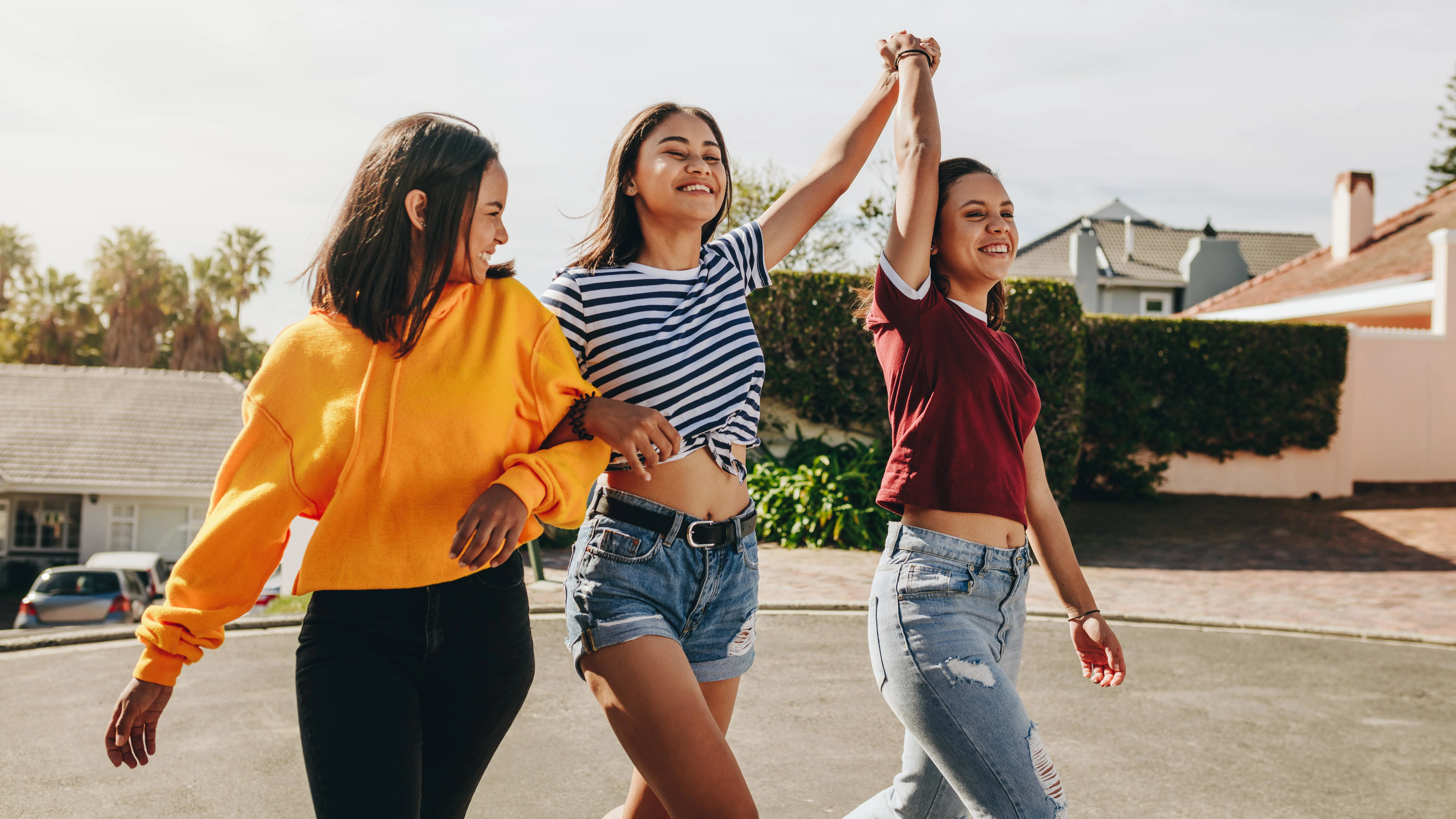 Girls walking and smiling while holding hands